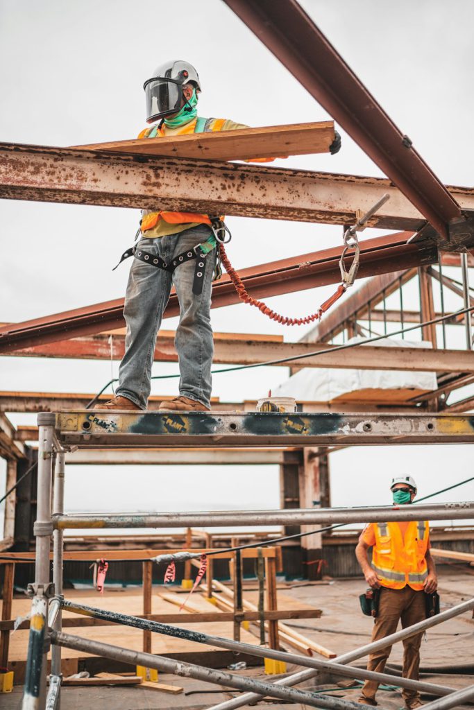 Construction worker on scaffolding near steel beams