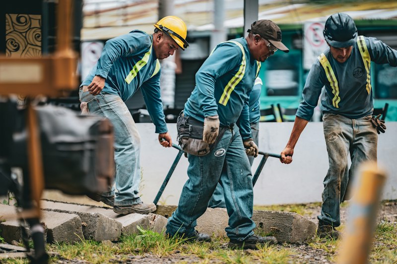 Construction workers laying railroad track together