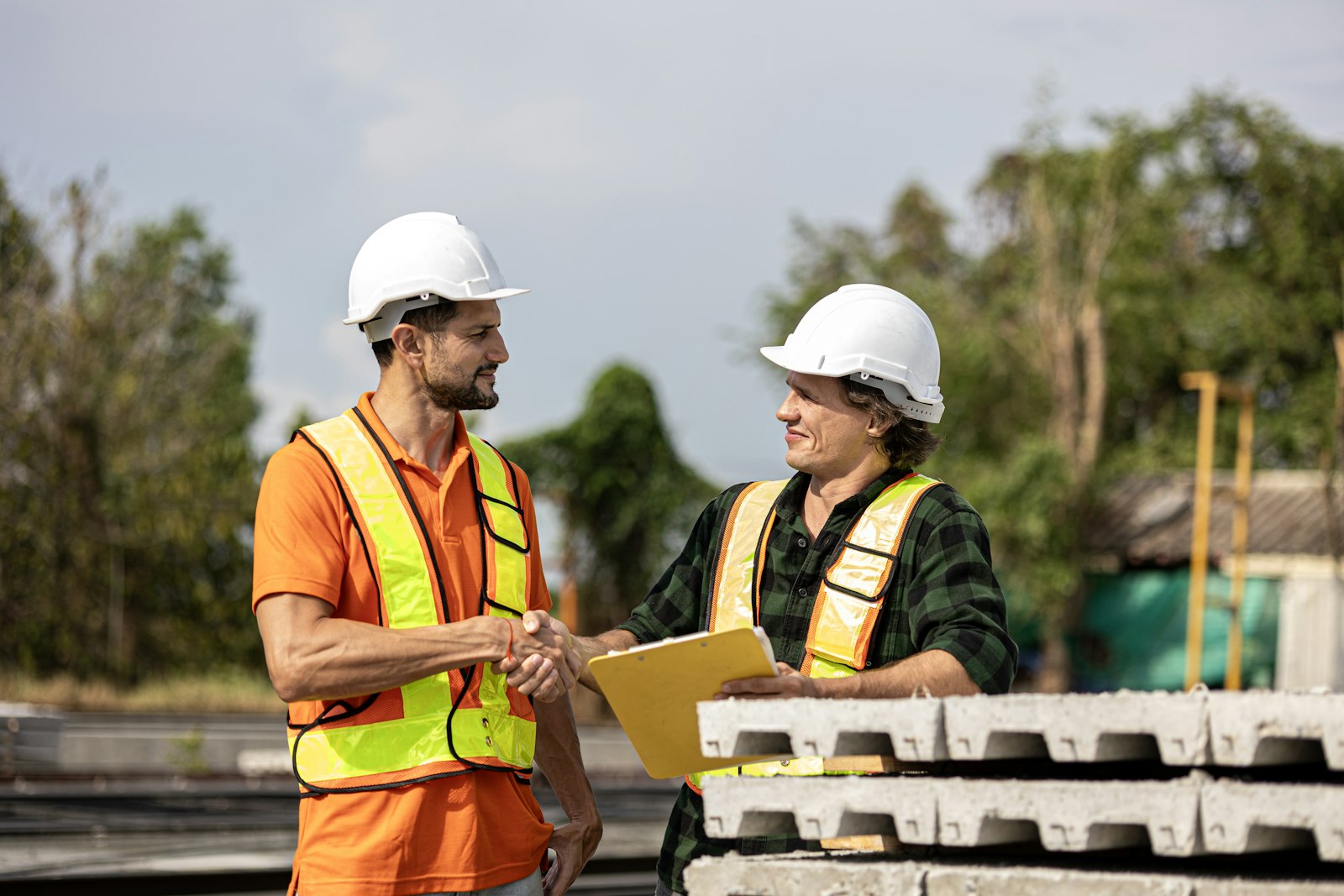 Construction workers shaking hands on site