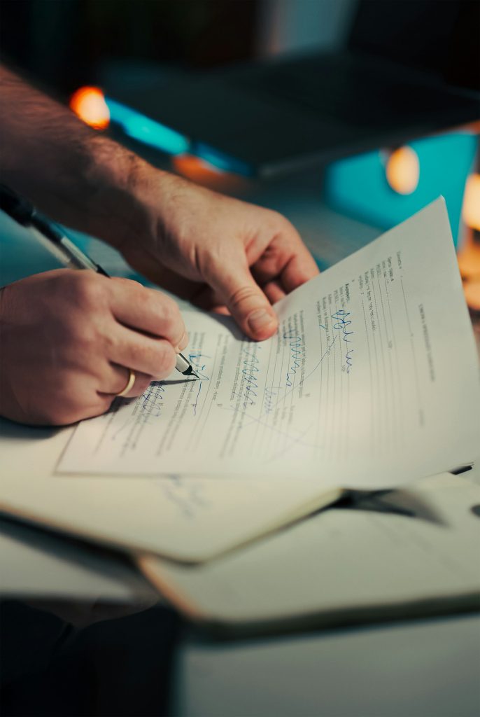 Employee signing a document with a pen