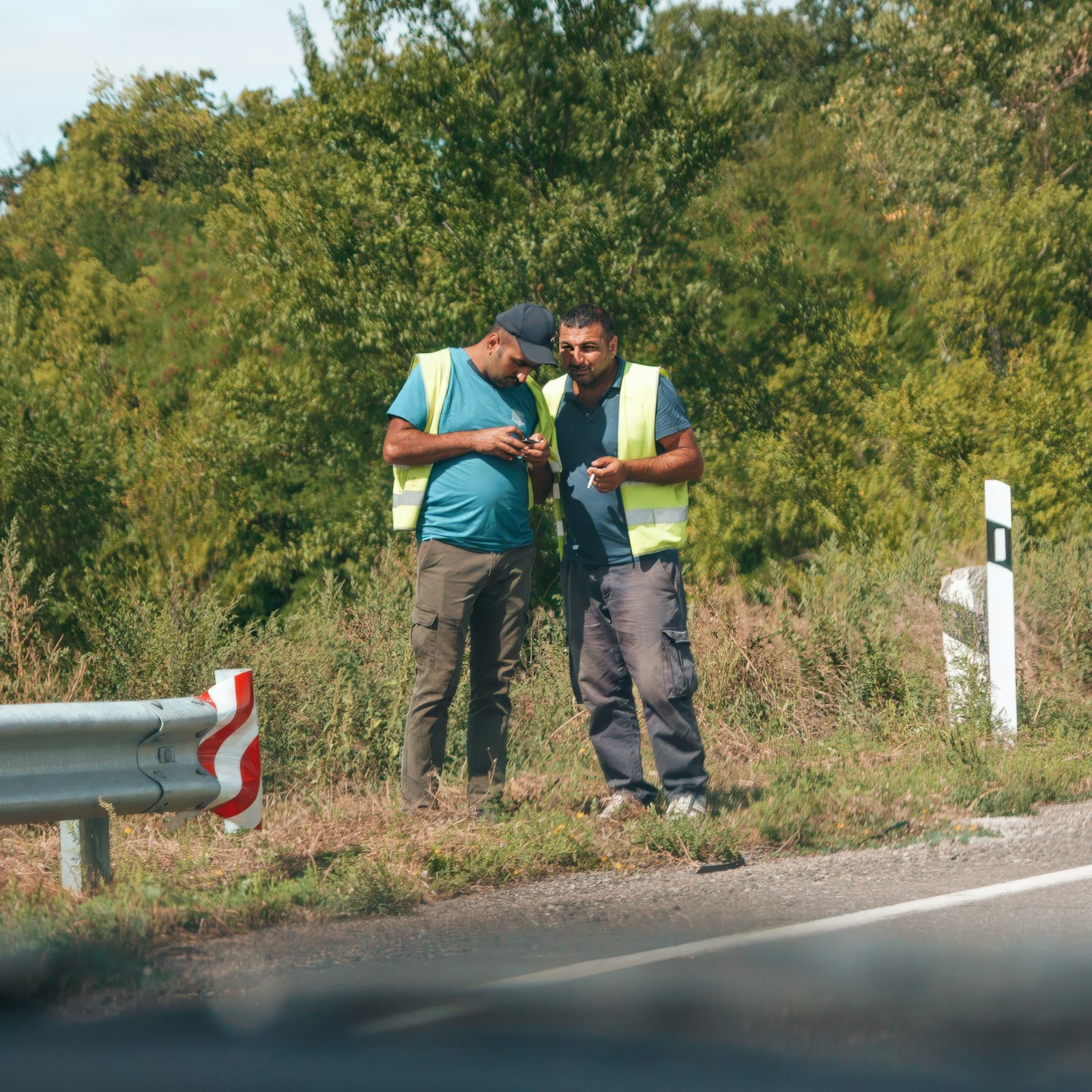 Two men talking by a roadside work area