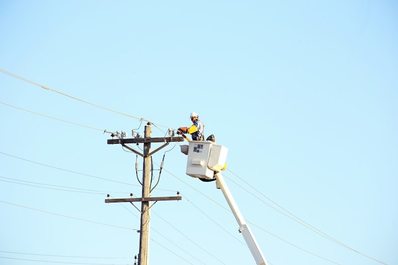 Lineman in a bucket beside a utility pole