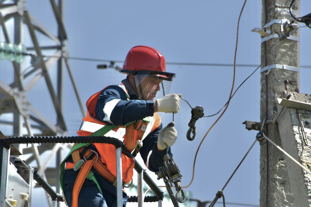 Lineman in safety gear on a power pole