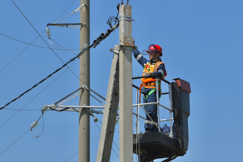 Lineman on a pole next to power lines