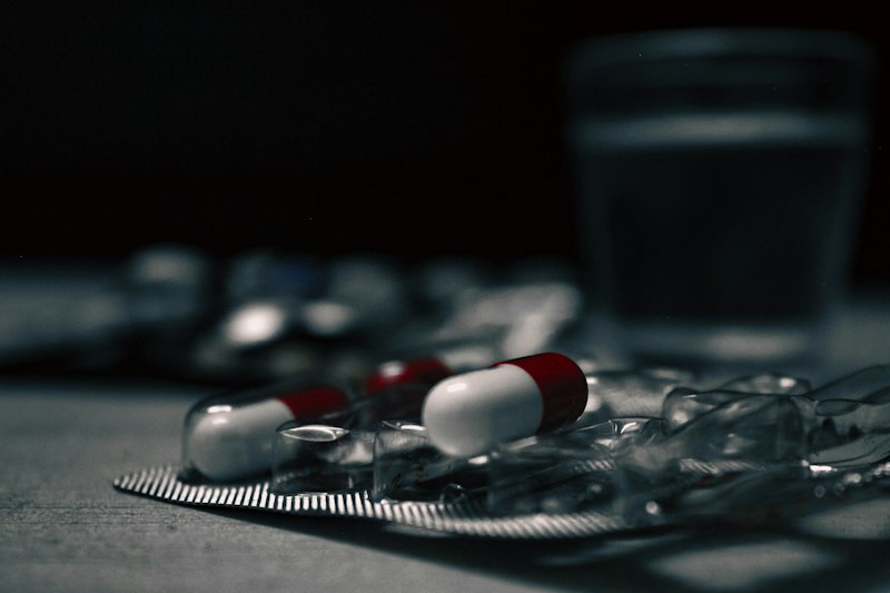 Pills beside a glass of water