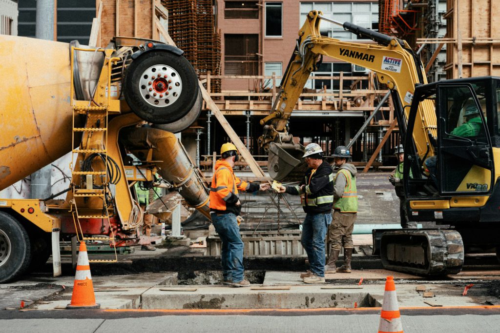 Two workers talking next to a construction site