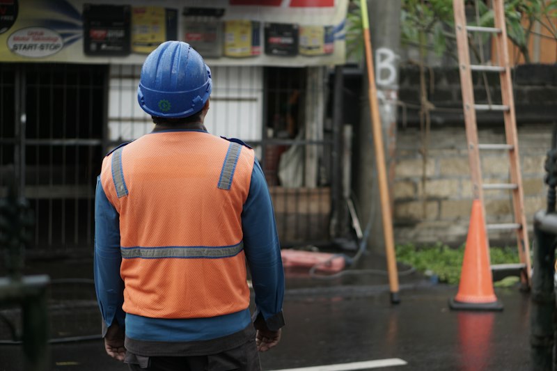 Worker in an orange vest and blue helmet