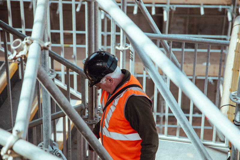 Worker standing under scaffolding